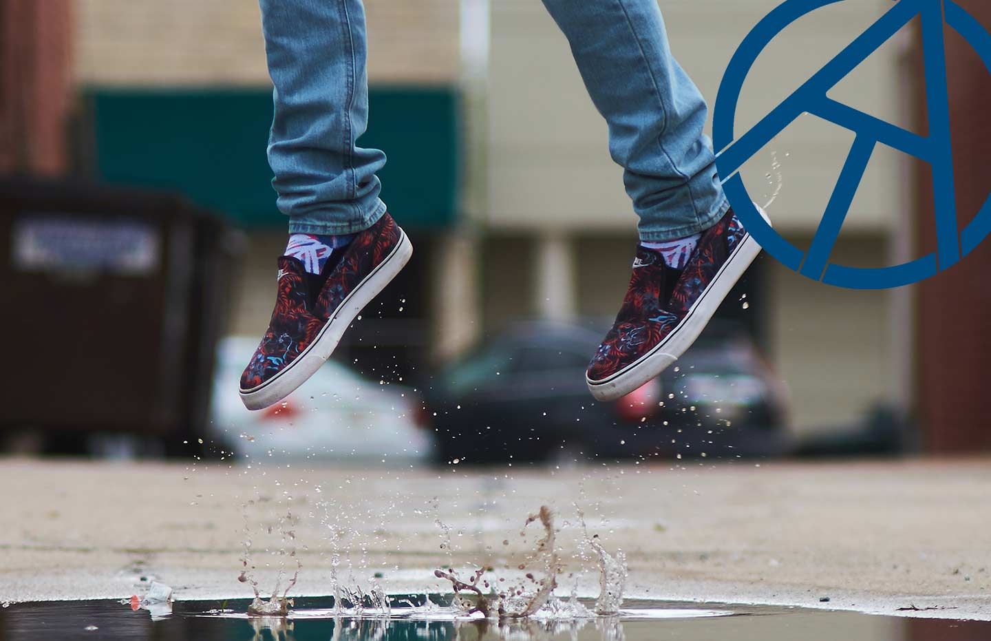 Person i sneakers hoppar över vattenpöl
